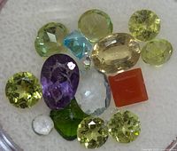All loose gemstones grouped together showing variety of colours and cuts