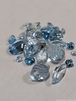 Group of loose faceted blue topaz stones assorted shapes
