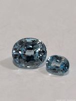 Front view of both blue zircon gemstones showing color and cut