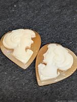 Two heart cameo cabochons on dark fabric