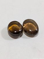 Front view of the two brown oval cabochon gemstones