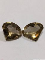 Two smokey quartz gemstones side by side showing facets and colour