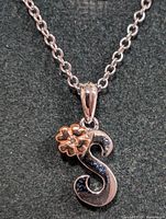 Full view of silver necklace and S pendant with flower accent