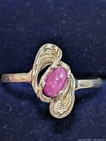 Top view of silver ring showing cabochon ruby in wrap setting