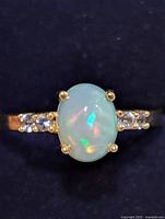 Front view of ring showing opal center stone and CZ accents