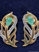 Front view showing emeralds and accent stones