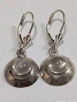 Front view of both silver drop earrings with moonstone cabochons