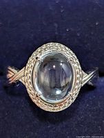 Top view of silver ring with oval blue topaz cabochon