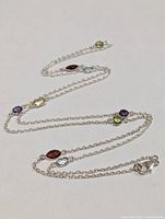 Full view of silver chain necklace with multicolour gemstones