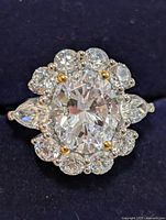 Top view showing centre oval CZ, halo, pear side stones and gold beads