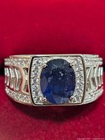 front view of silver ring with oval sapphire and halo