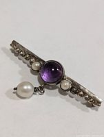 Front view showing amethyst cabochon and pearls