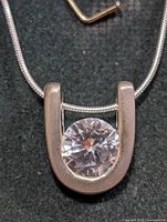 Front view of sterling silver necklace showing horseshoe pendant with round CZ