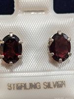front view of garnet studs in sterling silver setting