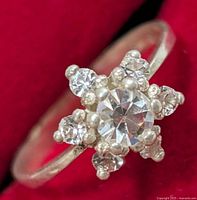 Front view of silver ring showing starburst cluster of clear stones