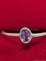 Front view of silver ring displaying oval tanzanite