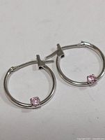 Front view of both hoop earrings showing pink CZ stones