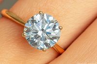 Close-up view of moissanite solitaire on yellow gold band