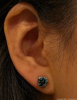 Earring worn on ear displaying size and setting