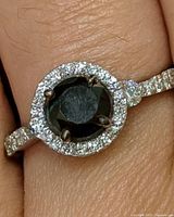 Ring on finger showing black diamond and CZ halo