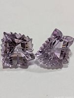 Two light-lavender amethyst gemstones shown side by side