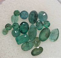 Group of emerald gemstones spread out for view of shapes and color