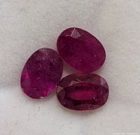 Three loose oval rubies close-up showing color and cut