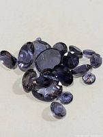 Group of loose faceted iolite gemstones on surface