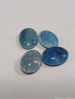 Four oval opal triplets on neutral background