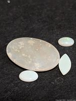 Four opal cabochons on dark background
