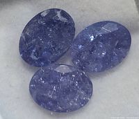 Close-up of three tanzanite stones showing color and inclusions