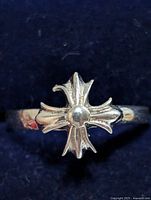 Front view of silver ring showing starburst cross design