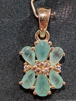 Front view of emerald cluster pendant showing stone arrangement and bail