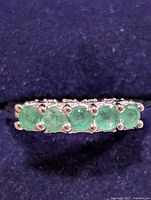 close-up of emeralds on ring in display box