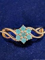 Front view of silver ring showing emerald cluster and shank design