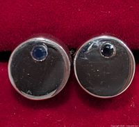 front view of both round silver earrings showing sapphire insets