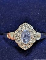 Top view of ring showing tanzanite center and halo of clear stones