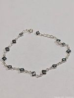 Full view of silver bracelet laid flat showing all stones