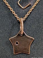 Close-up of star pendant front showing sapphire accent and bail
