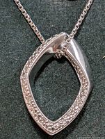 Marquise-shaped silver pendant with diamond accents on chain