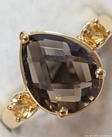 Top view of ring showing pear-cut smoky quartz and two citrine stones