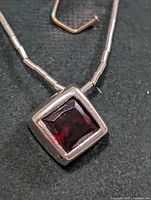 Close-up of garnet pendant showing bezel and chain detail