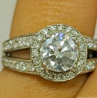 Close-up of ring on finger showing halo, split shank and pavé CZ accents