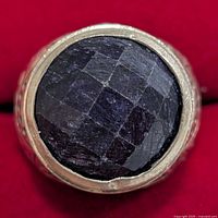 Top view of ring showing faceted dark gemstone in bezel