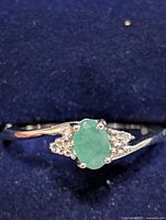 Top view of ring showing oval emerald and accent stones