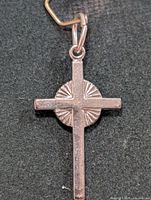 Front view of silver cross pendant on dark background