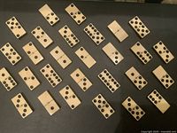 Overhead view of 28 cream domino tiles with black pips