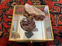 Top view of glass box with brass frame and two amethyst clusters inside