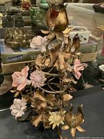 Overall view of gilt toleware candelabra showing ceramic flowers and three candle holders