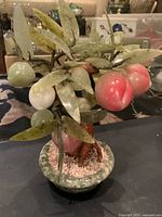 Front view of jade hardstone peach bonsai showing leaves, peaches and stone pot